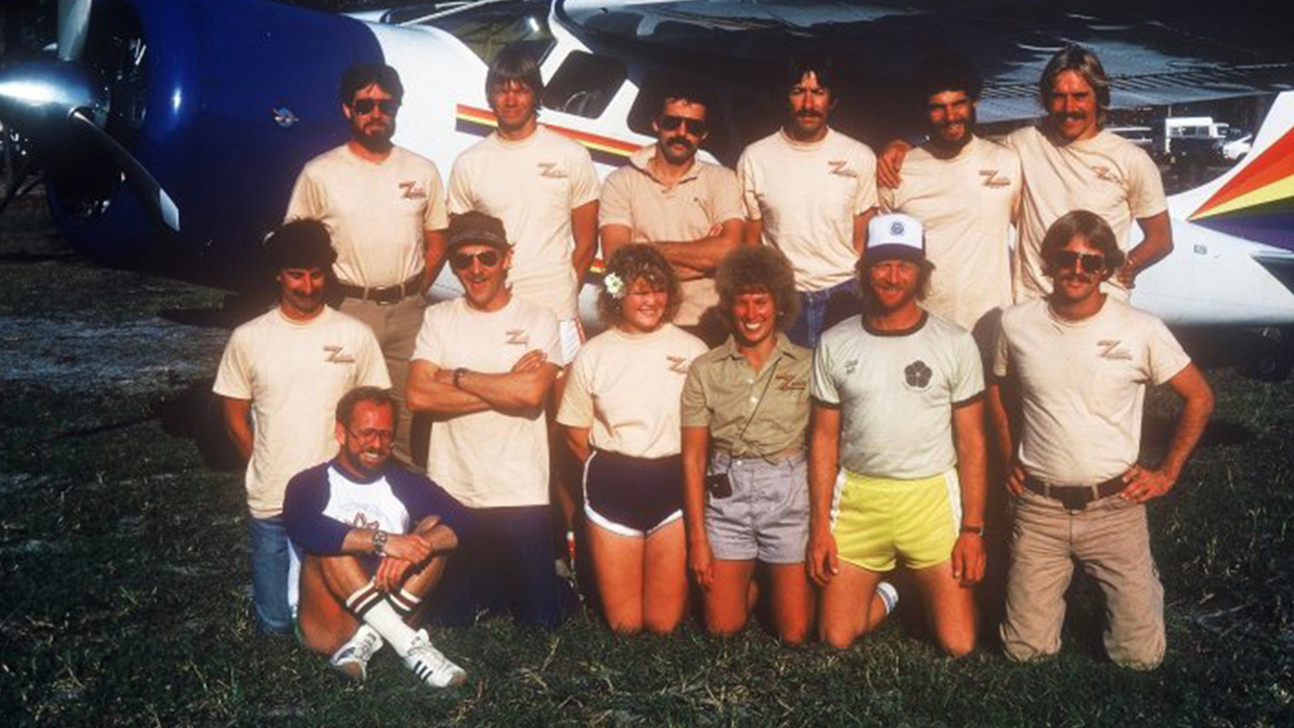 1970 Skydive City employees posing by airplane.