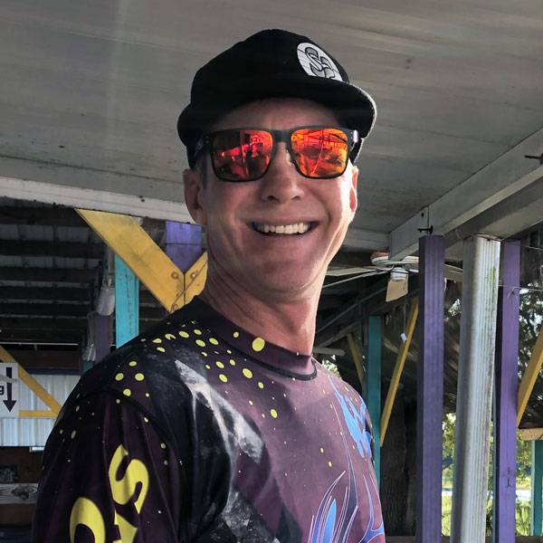 Cameron King smiling while wearing sunglasses and hat at Skydive CIty