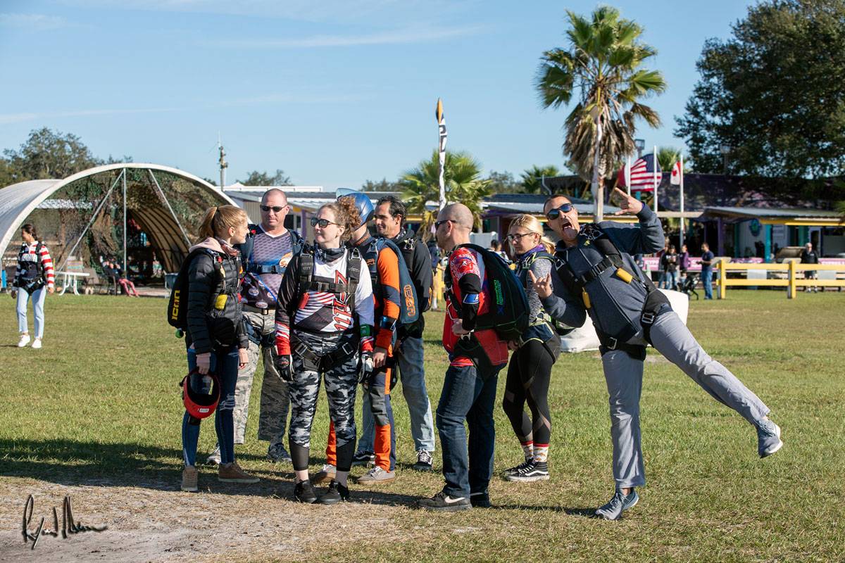Experienced skydivers suited up for jumping, enjoying a good time outside at Skydive City.