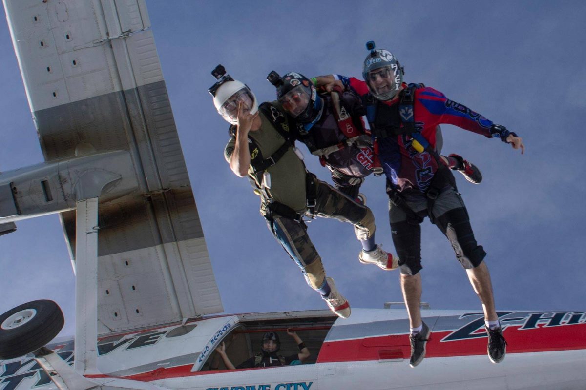 Experienced jumpers leaping from Skydive City airplane into free fall.