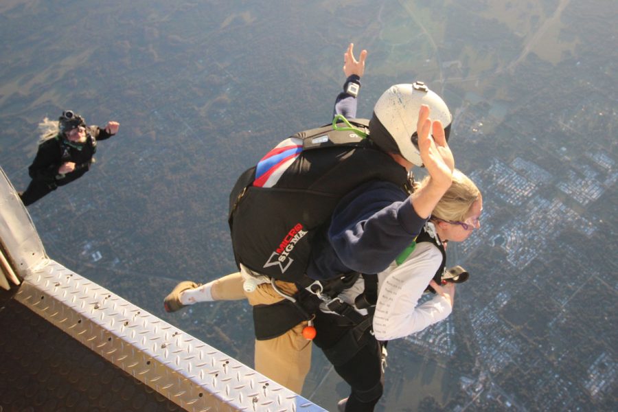 Women tandem jumper exiting Skydive City aircraft with instructor.