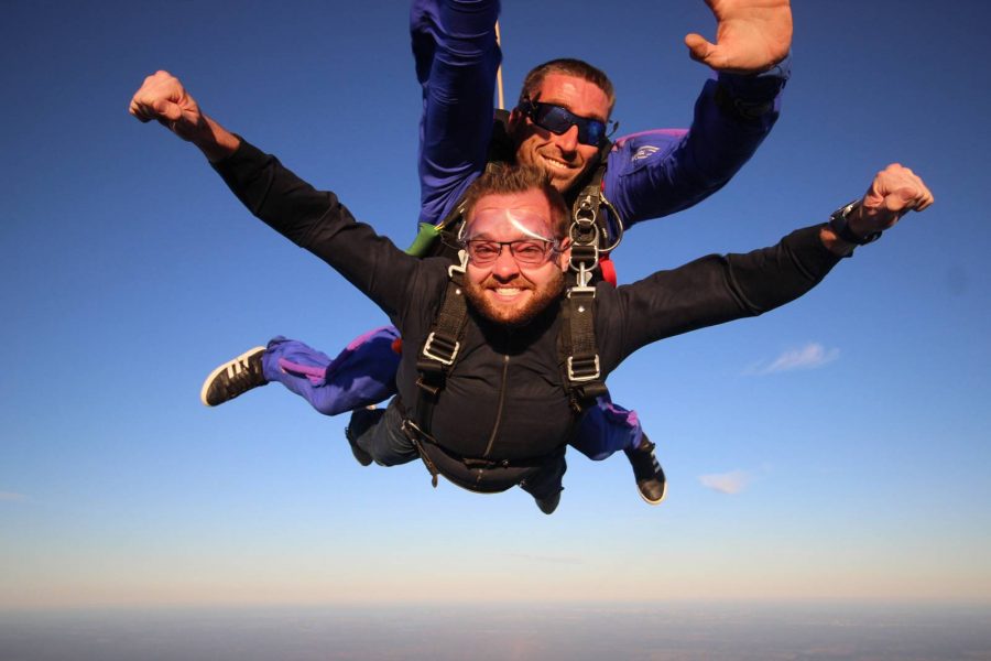 Male tandem jumper with arms out while in freefall with Skydive City tandem instructor.
