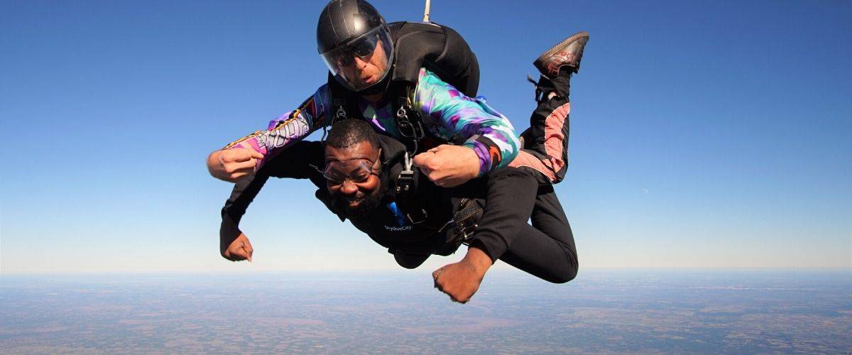 Male tandem skydiver happy to be in freefall with Skydive City tandem instructor